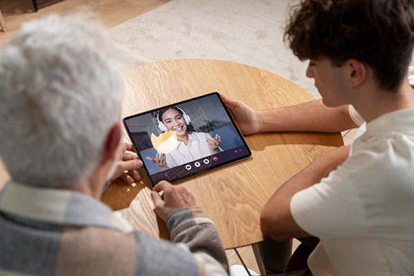 Séniors et numérique : dame âgée et jeune homme regardent YouTube
