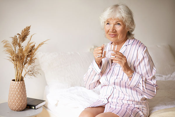 Seniors et canicule : une vieille dame qui boit de l'eau