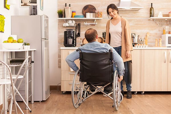 Aide à domicile et homme en fauteuil roulant